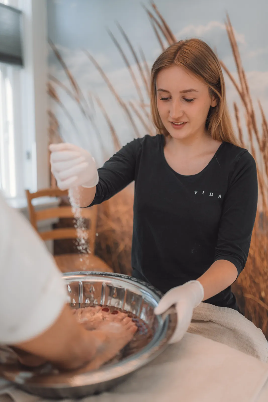 Behandler plejer fødder under en pedicure hos VIDA Skønhedsklinik